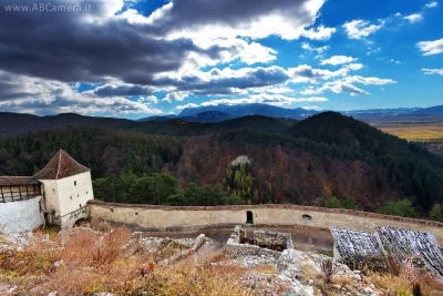 fotografia di un paesaggio boschivo con mura medievali in primo piano
