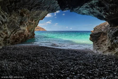 fotografia scattata con un grandangolo all'intero di una grotta sul mare
